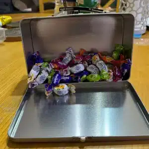 מזוודת פח כסופה מלאה סוכריות פתוחה זקוף